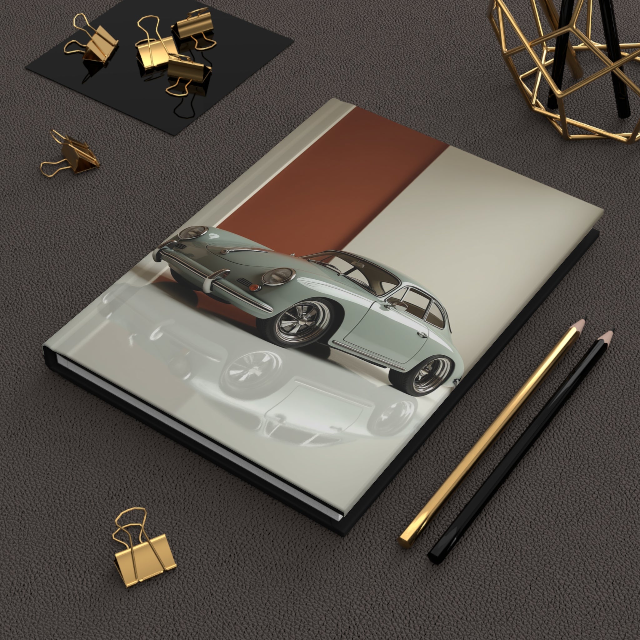 Notebook with porsche car illustration on a dark surface with office supplies