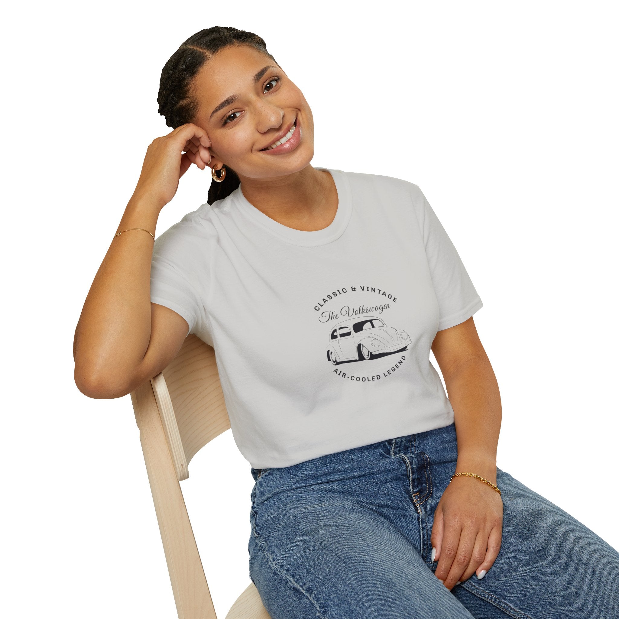 Woman wearing a white t-shirt with a graphic vw design, sitting on a chair against a white background