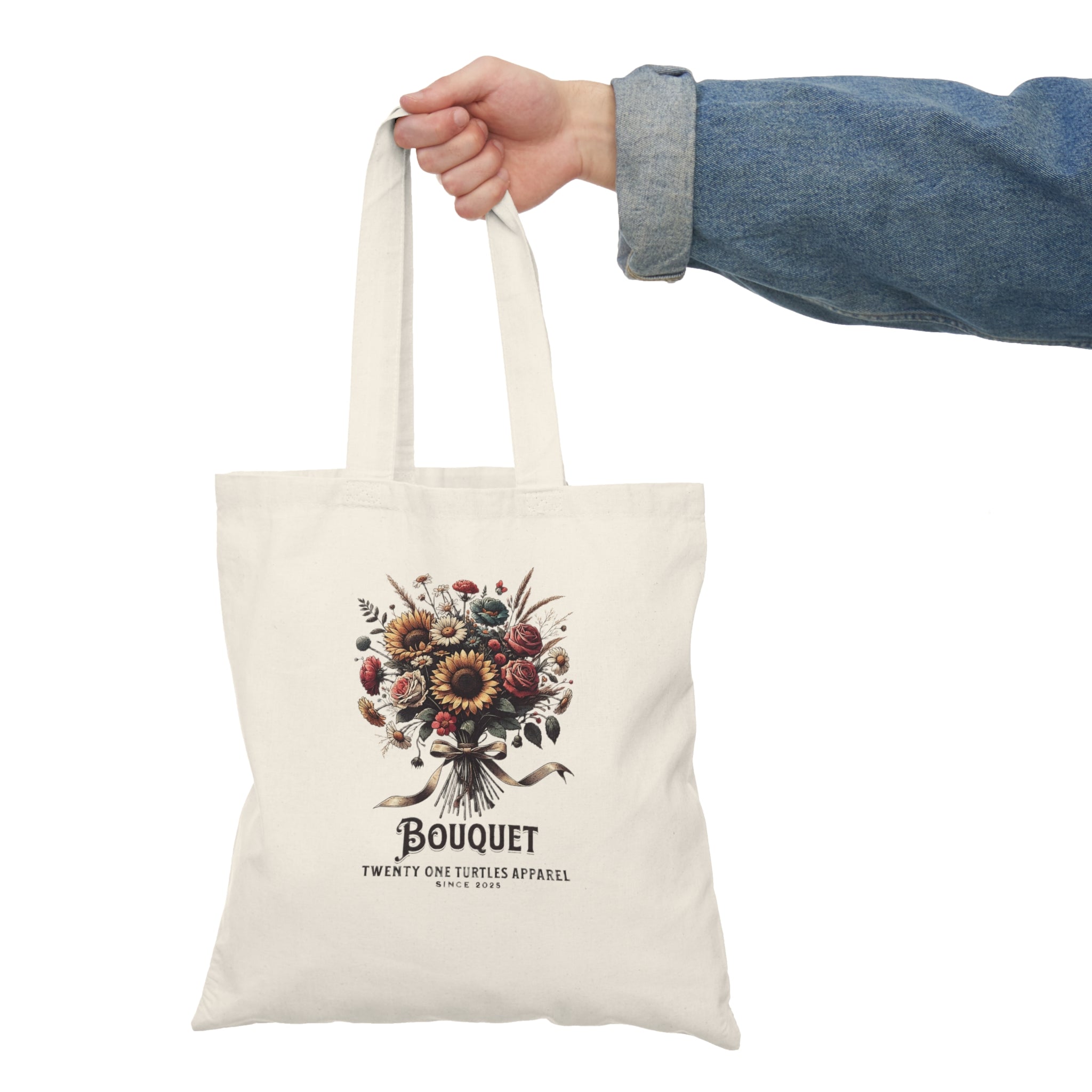 Tote bag with floral design and text held by a person wearing a denim jacket.