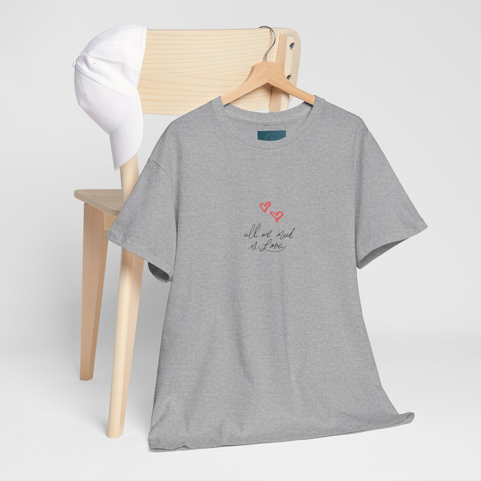 Gray t-shirt with text and heart design on a wooden hanger against a white background