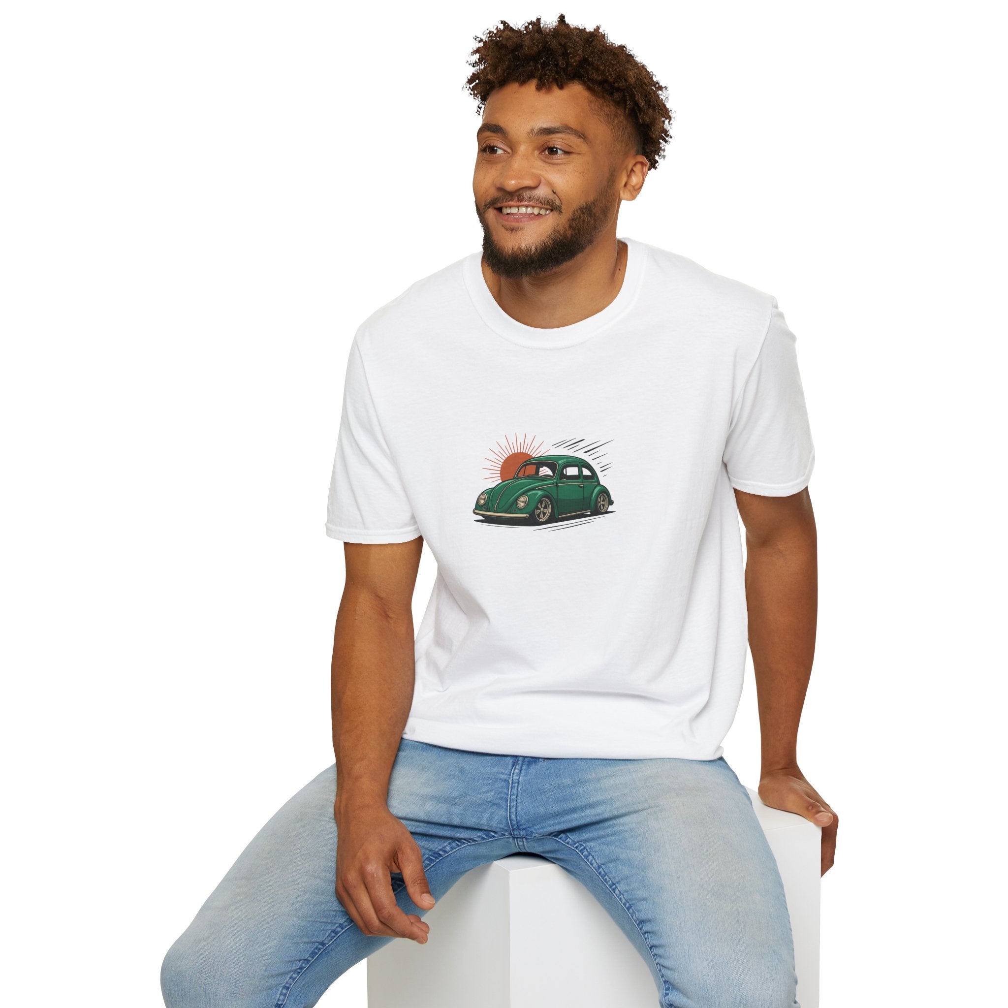Man wearing a white t-shirt with a VW Cal-look graphic design sitting on a white stool against a white background
