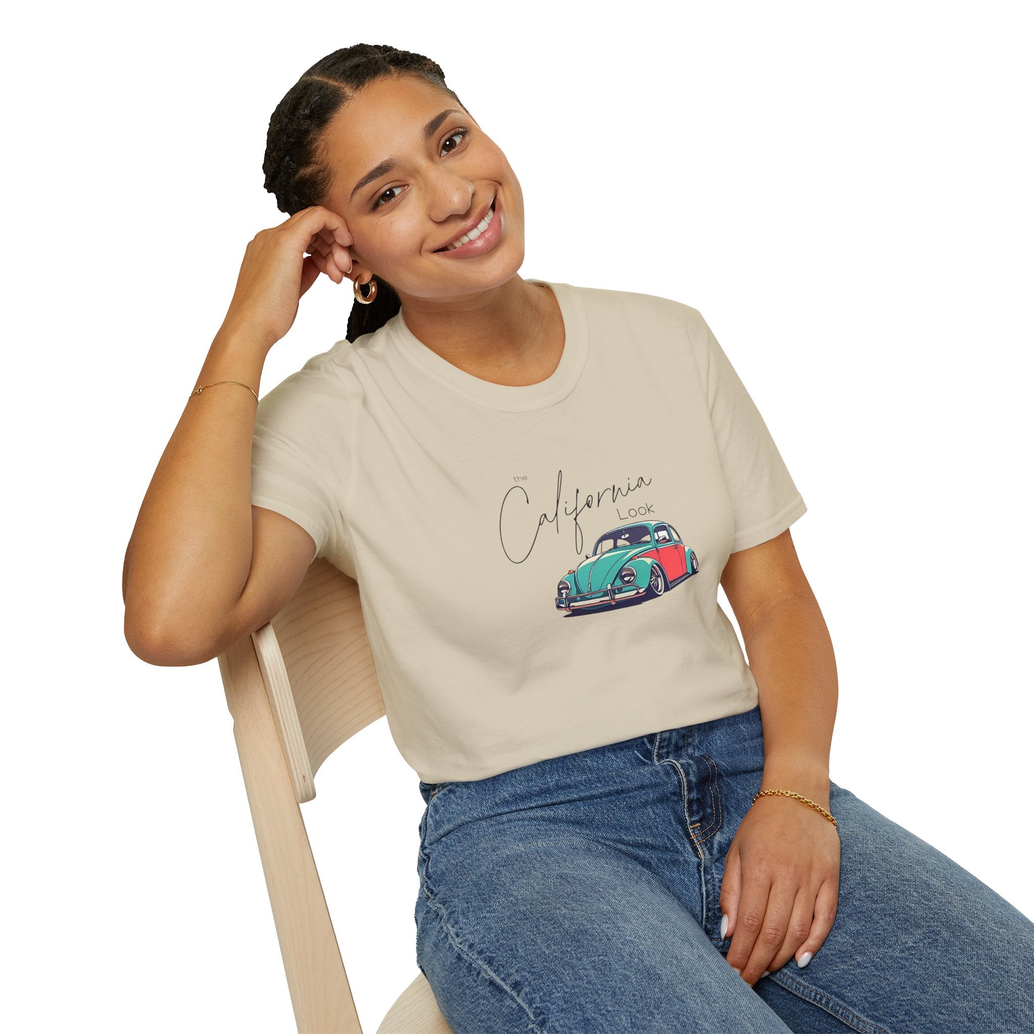 Woman wearing a beige t-shirt with a vw beetle graphic design sitting on a chair.