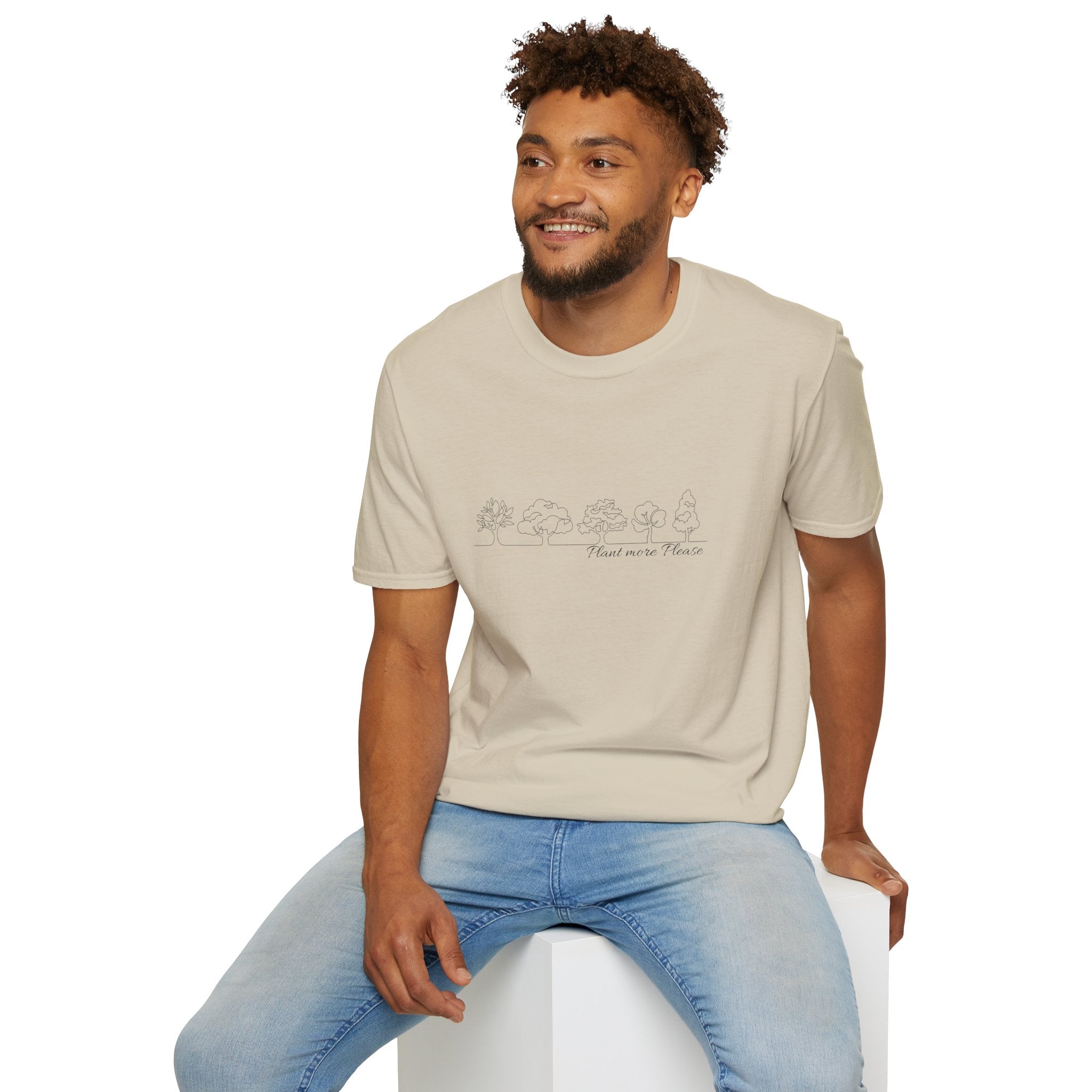 Man wearing a beige t-shirt with text and blue jeans sitting on a white stool against a white background