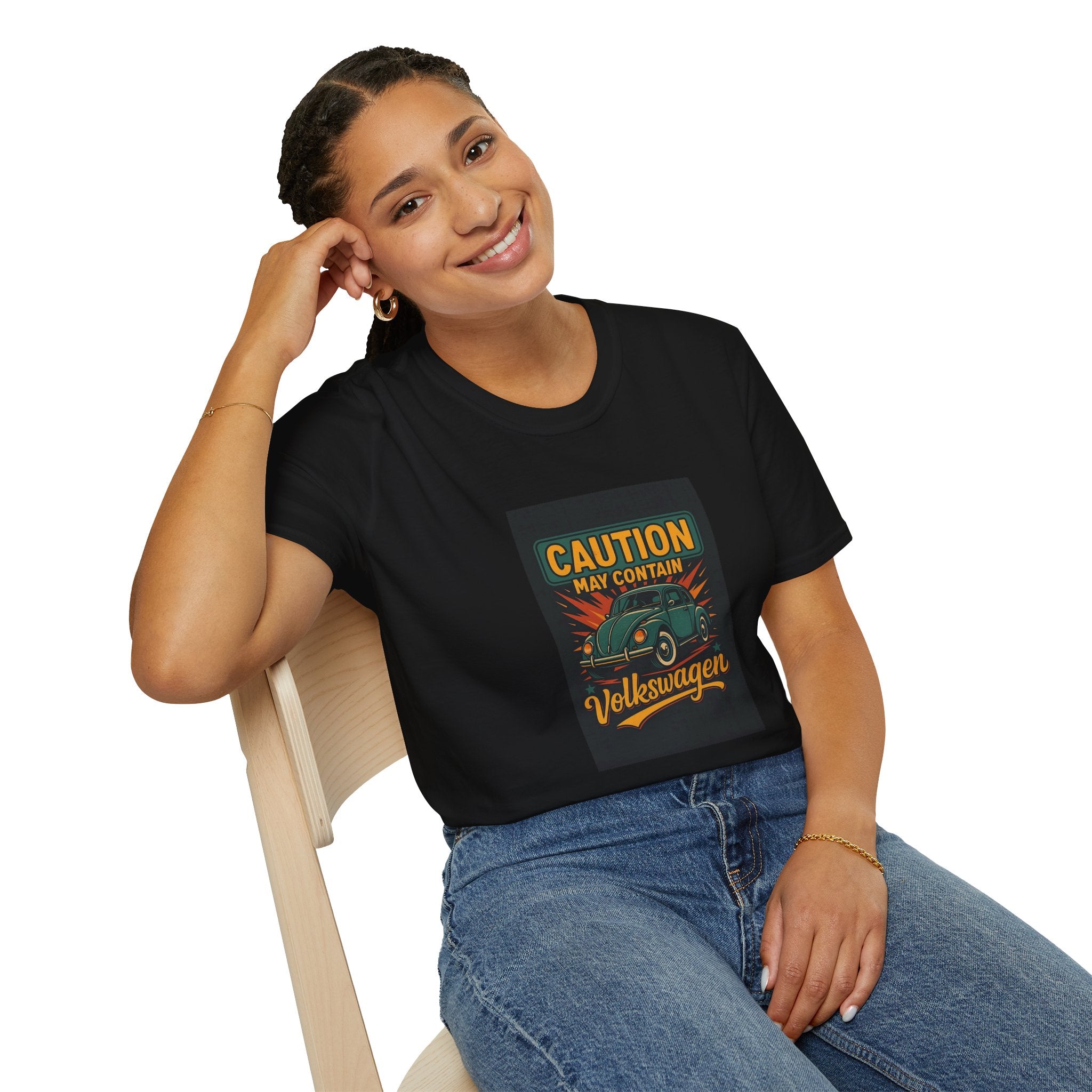 Woman wearing a black t-shirt with a VW graphic design sitting on a chair.