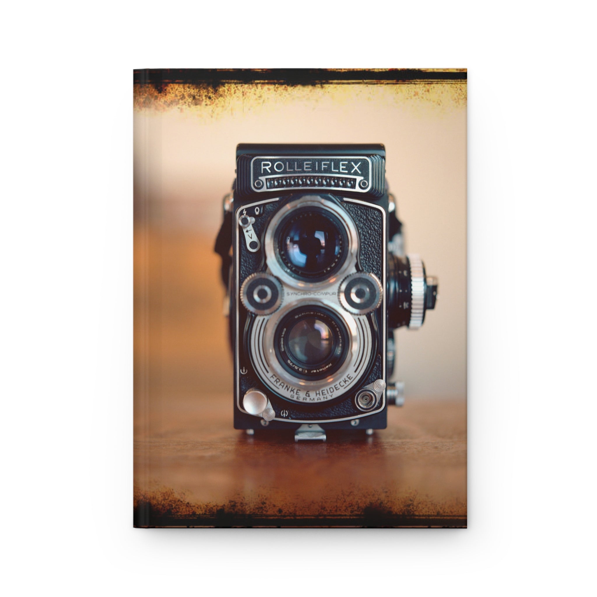 Vintage Rolleiflex camera on a textured surface with a warm color tone