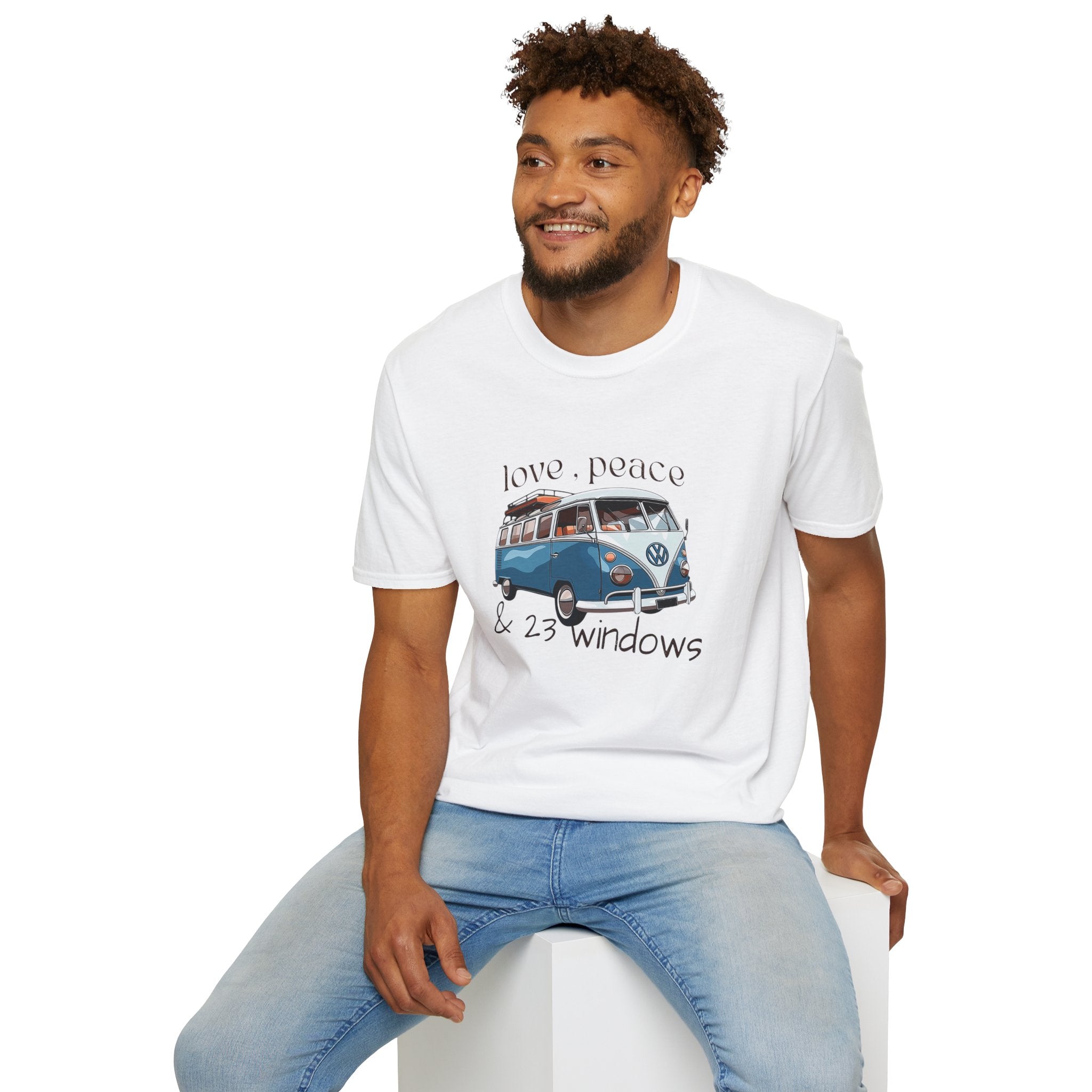 Man wearing a white t-shirt with a vw bus graphic design sitting on a white stool.