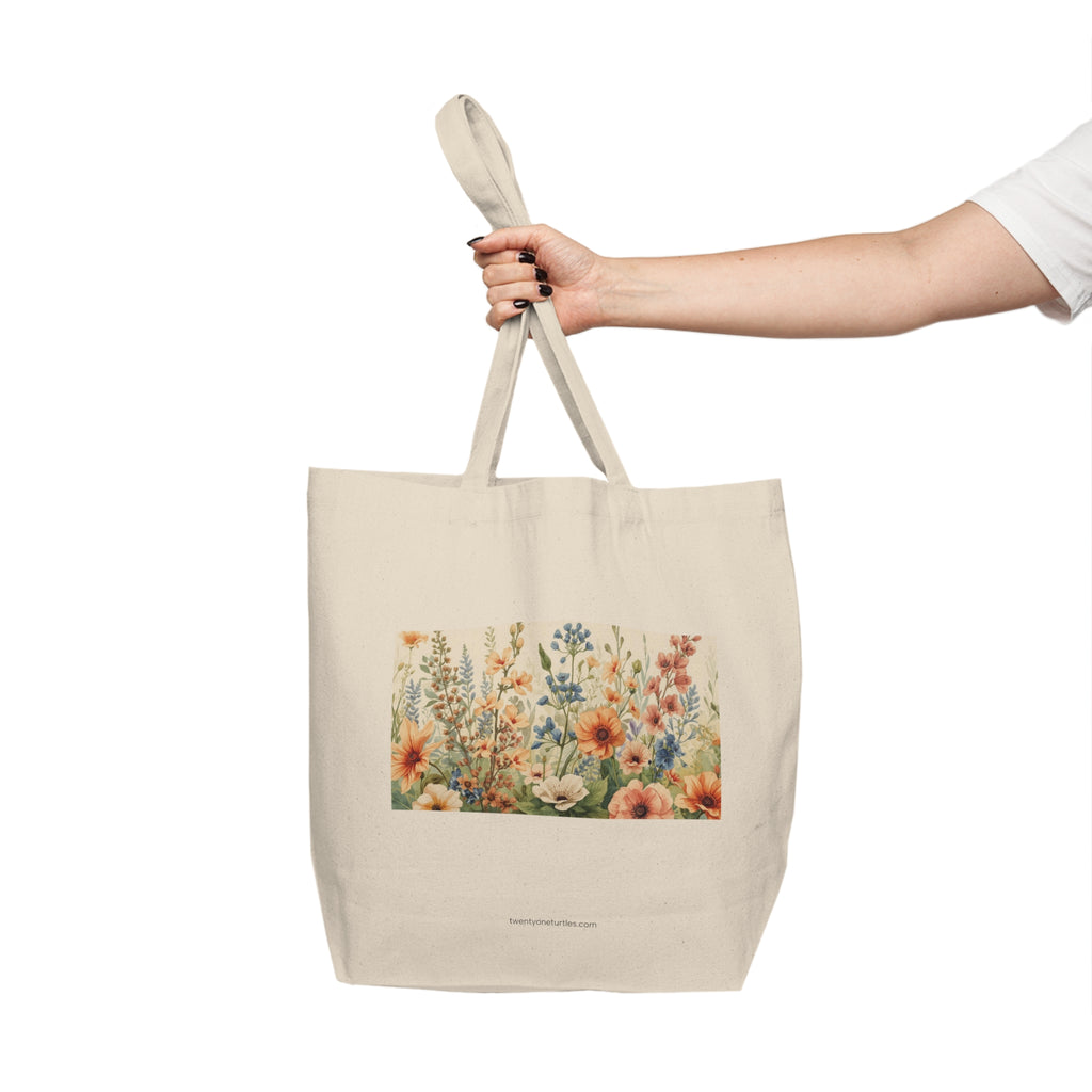 Tote bag with floral design held by a hand on a white background