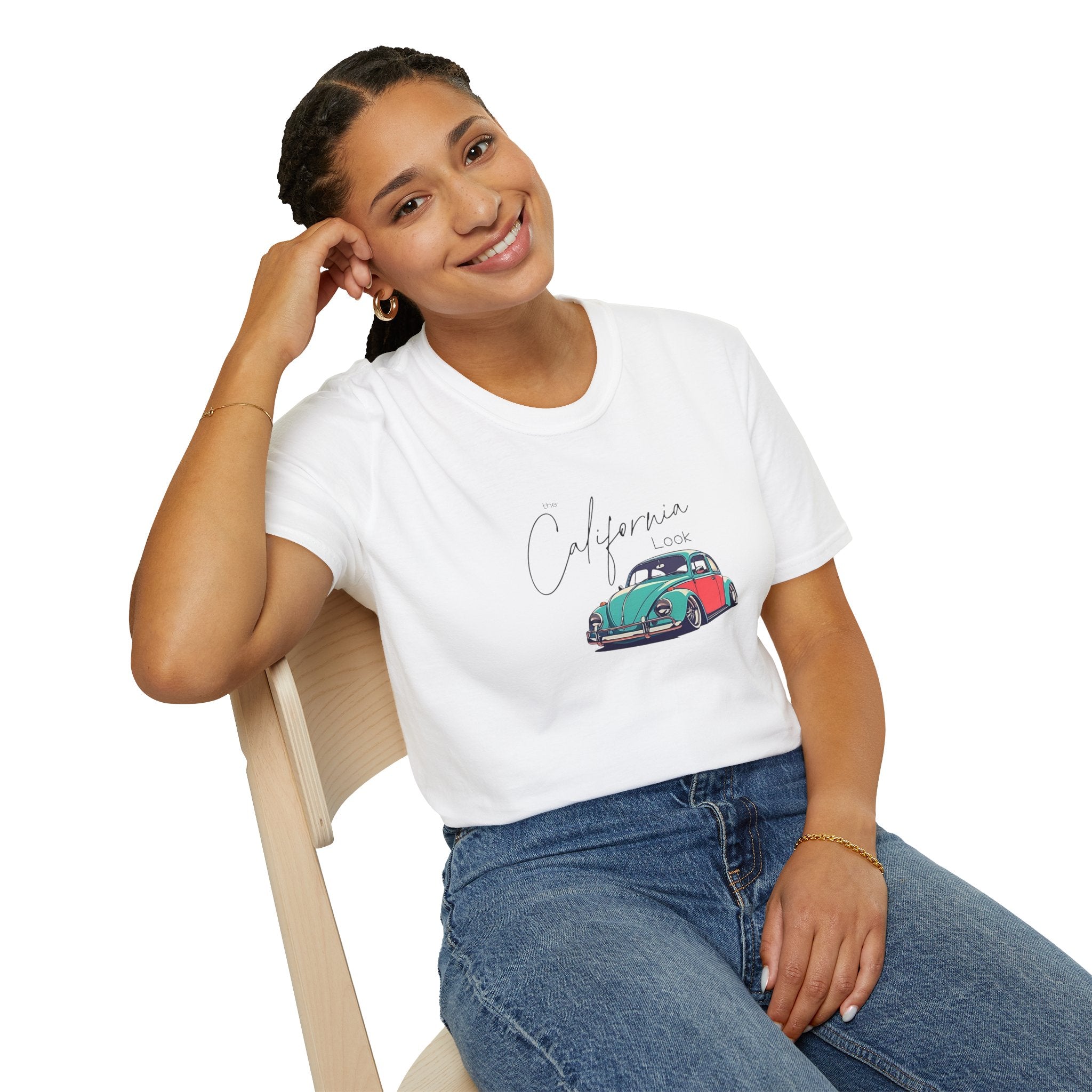 Woman wearing a white t-shirt with a vw cal-look graphic design sitting on a chair.
