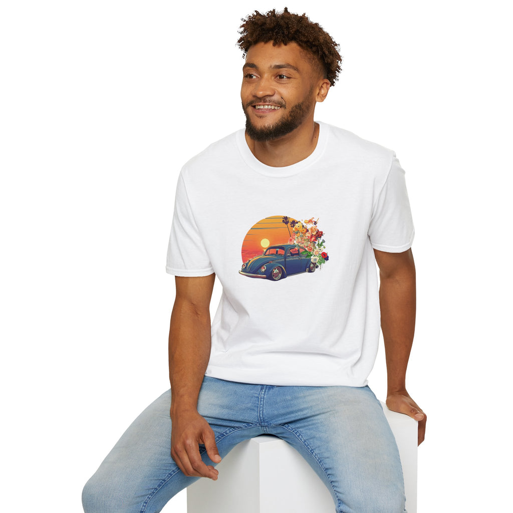 Man wearing a white t-shirt with a graphic design of a vintage vw car and sunset, sitting on a white stool against a white background.