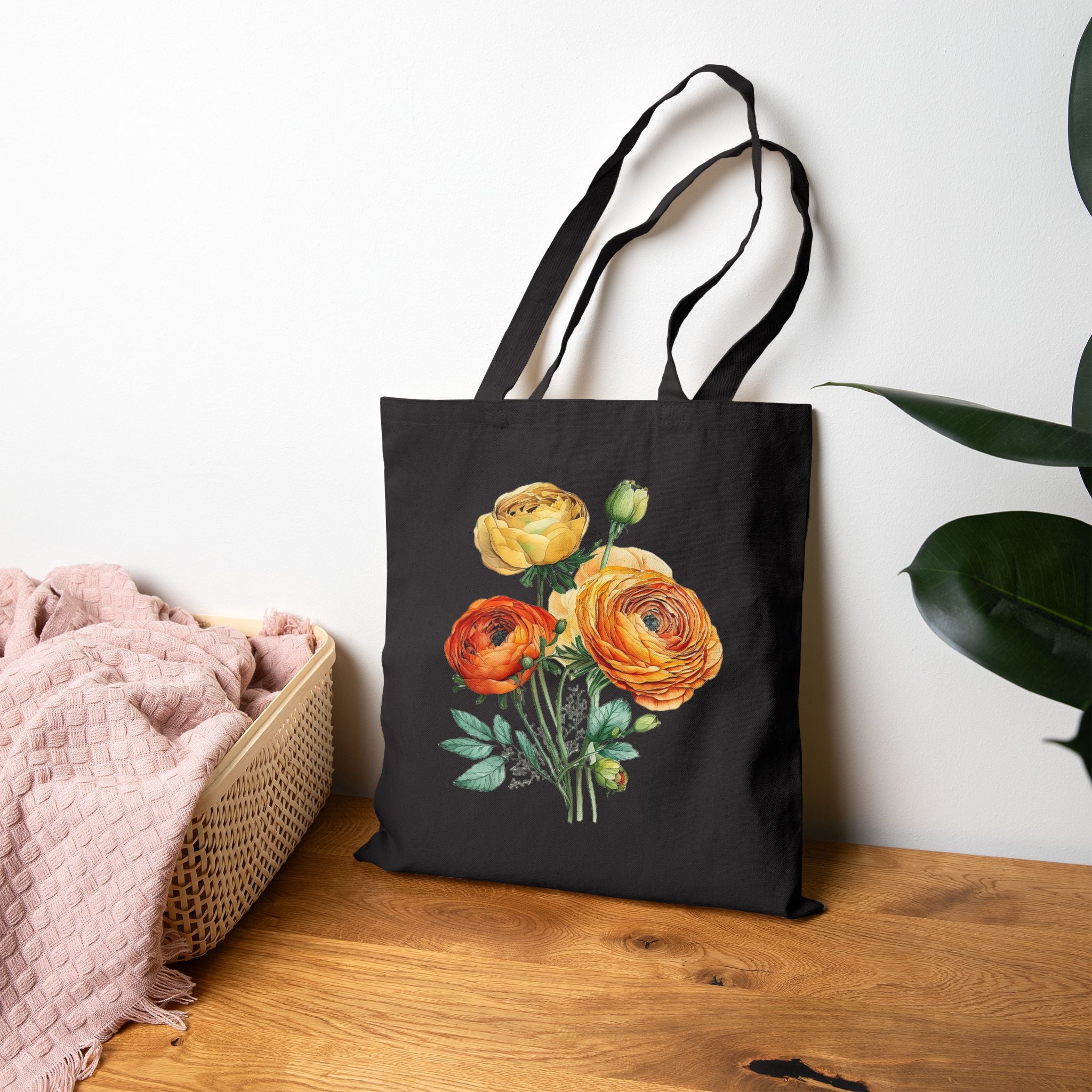 Black tote bag with floral design on a wooden surface