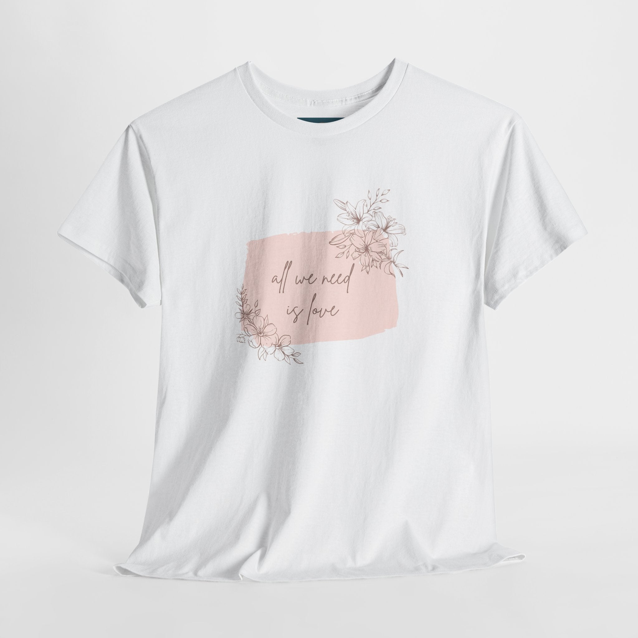 White t-shirt with a pink floral graphic and text on a light gray background