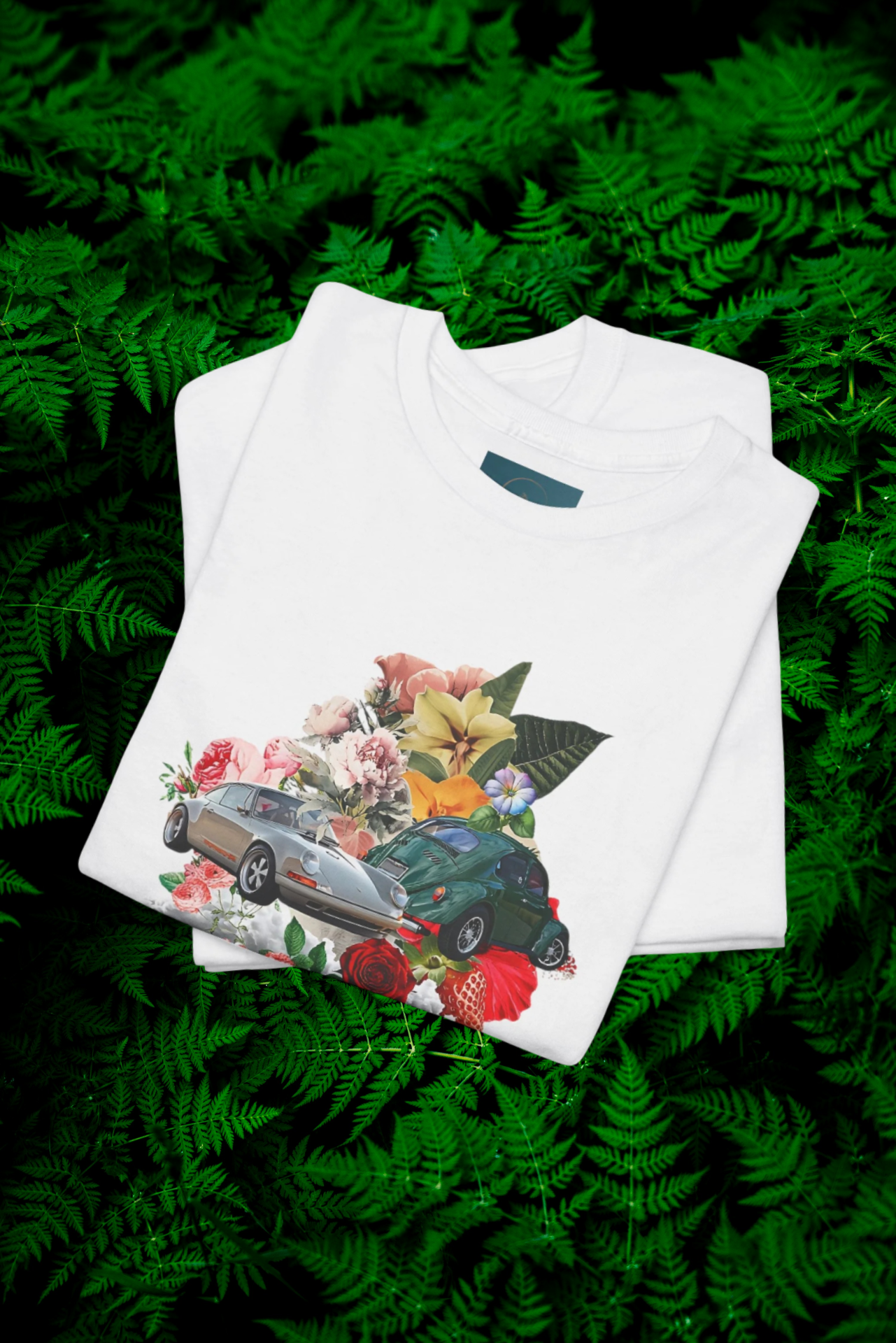 White t-shirt with car and floral design on green fern background