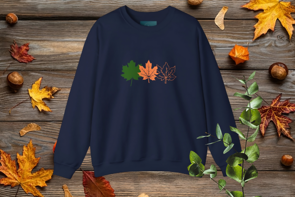 Navy blue sweatshirt with leaf designs on a wooden surface with autumn leaves and chestnuts.