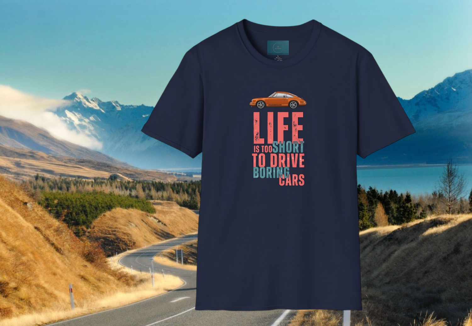 Navy blue t-shirt with a porsche graphic and text over a scenic road and mountain background