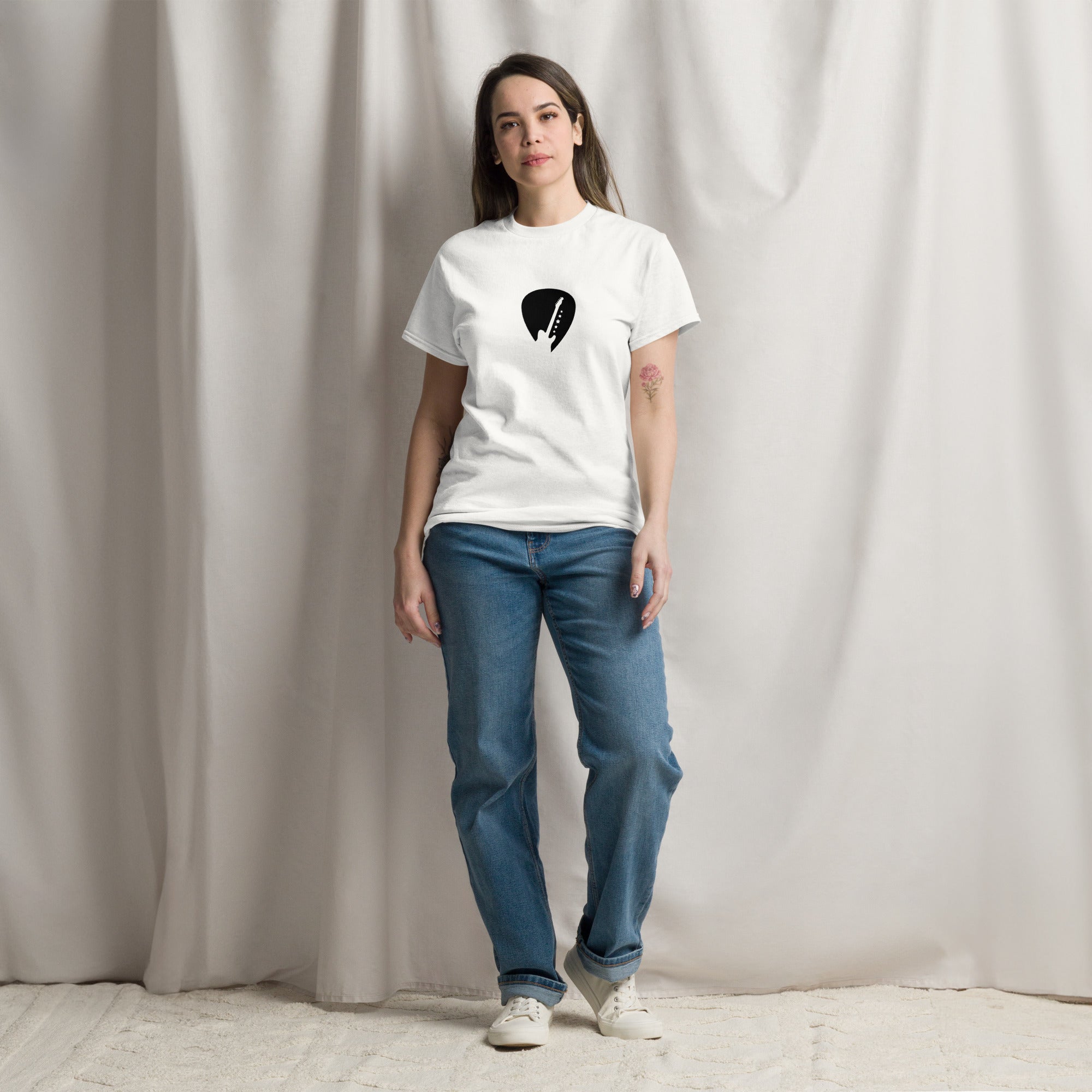Person wearing a white t-shirt with a black graphic design against a plain background