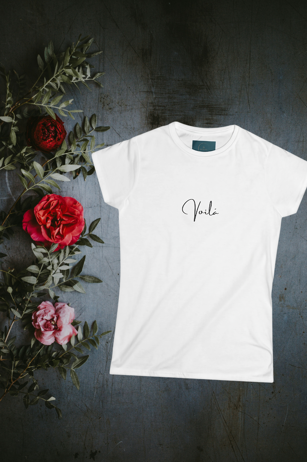 White t-shirt with 'Vera' text on a dark surface with flowers