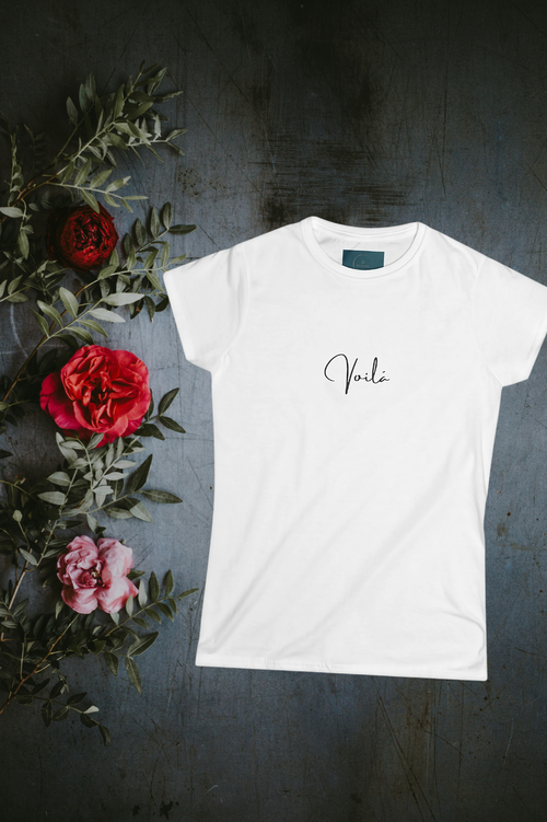 White t-shirt with 'Vera' text on a dark surface with flowers